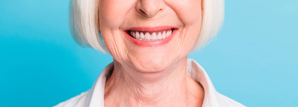 Femme âgé souriant avec des implants dentaires