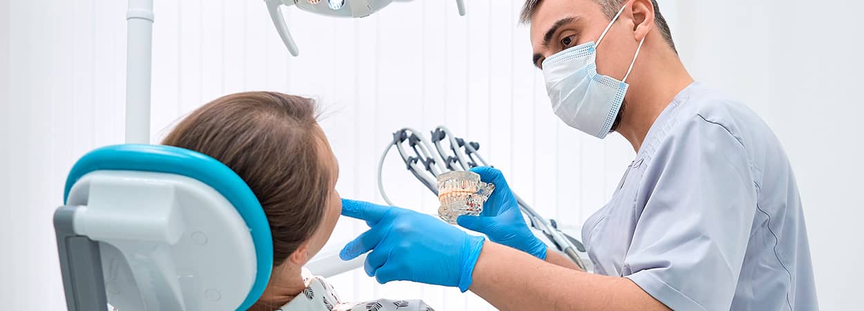 dentiste qui effectue un suivi pour des implants avec une patiente